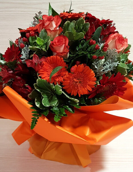 Bouquet di fiori misti sui toni del rosso 