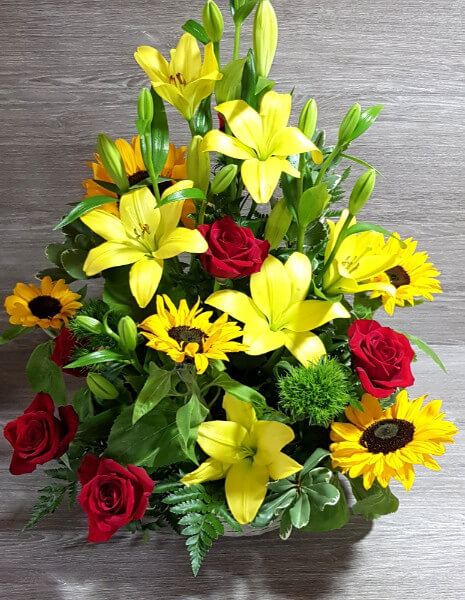 Cesto fiori nelle tonalità di colore rosso e giallo 