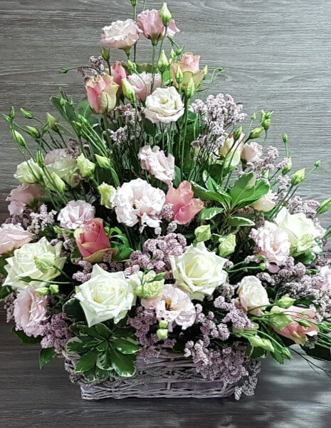 Cestino di vimini con fior bianchi e rosa e verdi decorativi